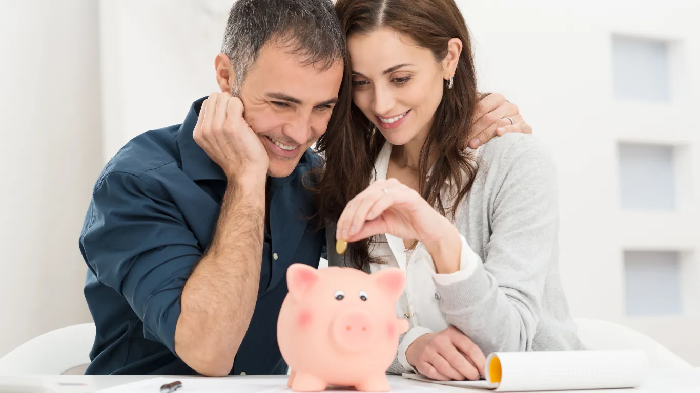 couple saving money, putting coins in piggy bank